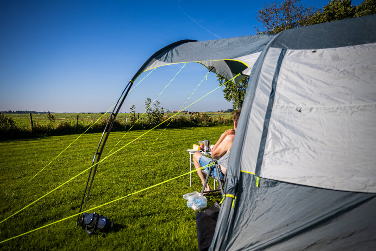 Een speciaal ingericht tentenveld met een ruim uitzicht over het Friese platteland met paarden en grasland op de achtergrond